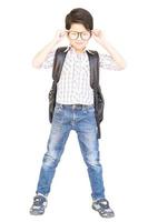 Seven year old Asian boy with a bag is ready to go to school isolated over white photo