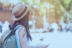 viaje turístico mujer mirando el mapa mientras camina en la estación de tren - concepto de viaje de mochila callejera foto