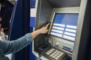 People waiting to get money from automated teller machine - people withdrawn money from ATM concept photo