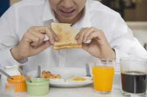 Business man eat the American breakfast set in a hotel - people take a breakfast in hotel concept photo