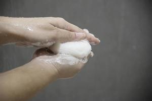 manos de señora con jabón en un cuarto de baño - concepto de cuidado de la salud limpio foto