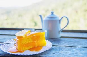 Hot eat cup and orange cake with green nature background - food and drink in wild nature concept photo