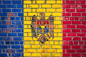 bandera nacional de moldavia sobre un fondo de ladrillo grunge. foto