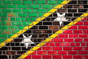 National  flag of the Saint Kitts and Nevis  on a grunge brick background. photo