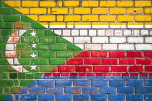 National  flag of the  Comoros  on a grunge brick background. photo