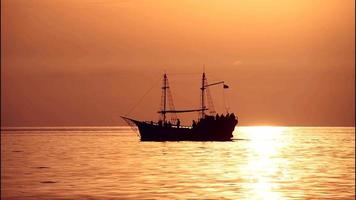 cinemagraph van het zeegezicht met het silhouet van het schip tegen de achtergrond van de zonsondergang video