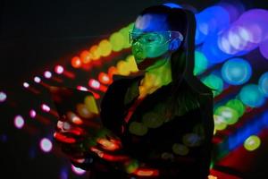 Confident woman in futuristic glasses using digital tablet against colorful background photo