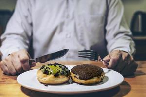 Guy cutting donuts to eat photo