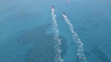 windsurfers in actie. luchtfoto van te hard rijdende windsurfers. a windsurfers met hun prachtige uitzichten hebben een prachtige dag in Alacati, Cesme Turkije bij zonsondergang. video