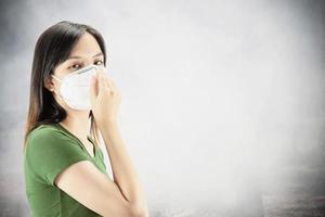la joven que usa máscara protege el polvo fino en el ambiente de contaminación del aire - personas con equipo de protección para el concepto de contaminación del aire foto
