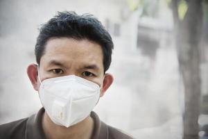 Man wearing mask protect fine dust in air pollution environment - people with protection equipment for air pollution concept photo