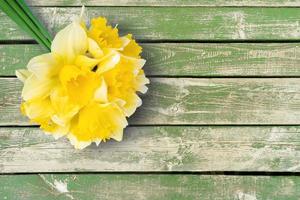 ramo de narcisos amarillos, narcisos sobre fondo de madera verde con espacio para copiar foto