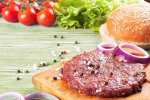 The ingredients for the burger on green wooden background photo