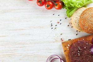 The ingredients for the burger on white wooden background photo