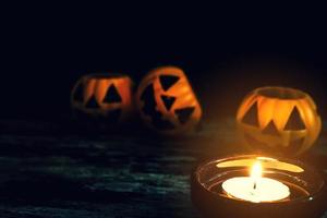 Candles and Halloween pumpkins are placed on wooden floors. photo