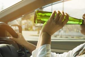 mujer bebiendo cerveza mientras conduce un coche foto
