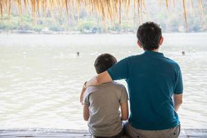Happy dad and son during vacation at water site nature - happy family vacation concept photo