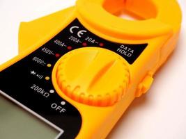 Picture of yellow digital clamp meter that using for measuring electrical current, voltage and resistance photo