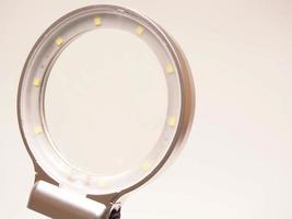 Close up shoot of printed circuit board PCB sitting on a white repair stand with magnifier for better examining small parts photo