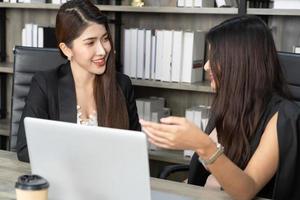 Young women in office working together on desktop photo