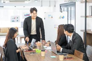 Selective Focus. Business presentation. project manager pointing at desktop presenting statistical data, briefing diverse group of employees. demonstrates statistics. photo