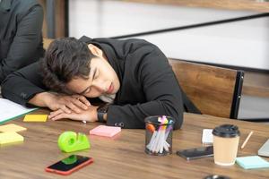 Businessman knock down on desk. overload working or deteriorating health or failure business down trend. Sleeping on the Desk at Work. photo