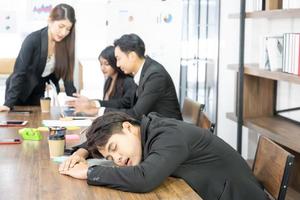 el hombre de negocios derriba el escritorio. sobrecarga de trabajo o deterioro de la salud o fracaso de la tendencia empresarial. durmiendo en el escritorio en el trabajo. foto