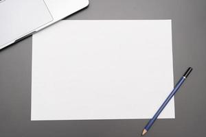 papel en blanco de mesa de oficina con lápiz. el papel en blanco se puede utilizar para poner texto o imágenes. foto