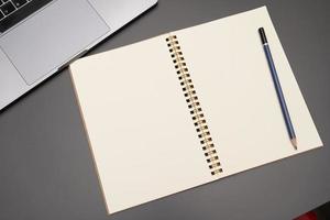 Blank notepad and pencil color on gray background photo