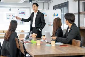 Selective Focus. Business presentation. project manager pointing at desktop presenting statistical data, briefing diverse group of employees. demonstrates statistics. photo