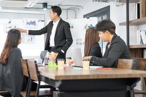 Selective Focus. Business presentation. project manager pointing at desktop presenting statistical data, briefing diverse group of employees. demonstrates statistics. photo