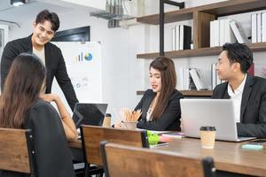 Selective Focus. Business presentation. project manager pointing at desktop presenting statistical data, briefing diverse group of employees. demonstrates statistics. photo