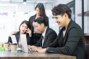 Portrait of business man using computer at workplace in an office. positive business man smiling looking into screen of computer. photo