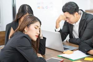 Business team members sleeping on desk and chairs. A business team is tired from a long meeting. photo