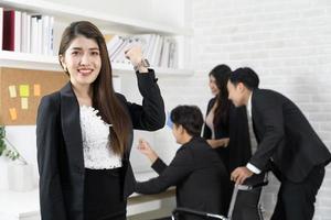 Beautiful professional Asian business woman smiles happily successful while looking at the camera. business woman is standing and cheerful with proud of her success photo