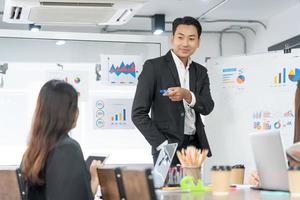 Selective Focus. Business presentation. project manager pointing at desktop presenting statistical data, briefing diverse group of employees. demonstrates statistics. photo