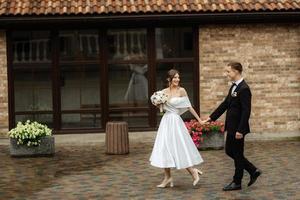 young couple bride and groom in a white short dress photo