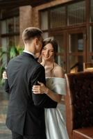 young couple bride and groom in a white short dress photo