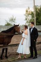 young couple the groom in a black suit and the bride in a white short dress photo