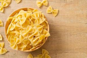 Dry uncooked farfalle pasta in bowl photo