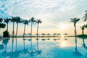 umbrella with bed pool around swimming pool with ocean sea background photo