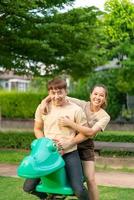 A la pareja asiática le encanta sonreír y sentarse en un caballo rocoso foto