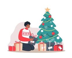 el hombre pone regalos debajo del árbol de navidad vector