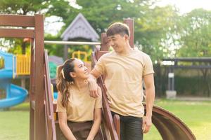 Asian couple love smiling in kids playground photo