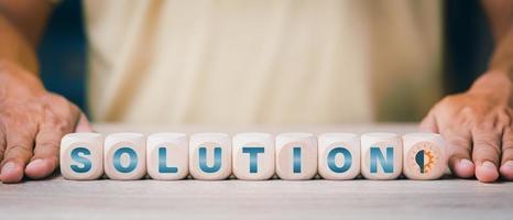 a businessman showing a wooden block with the word solution,Ideas and strategies to advise and connect creativity, inspiration,Brainstorming for effective goals, solving problems together photo