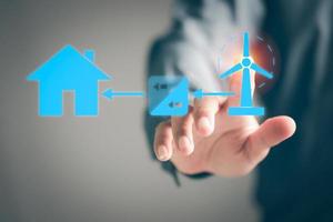 A young businessman points to the wind turbine icon that turns from wind to electricity, alternative energy concepts to conserve resources. , innovative green energy derived from nature photo