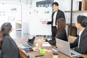 Business presentation. project manager pointing at desktop presenting statistical data, briefing diverse group of employees. demonstrates statistics, various personnel attending the training. photo