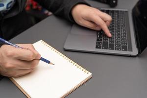 Selective focus, business people hand in suit writing on notebook or using smartphone. A businesswoman writing a note photo