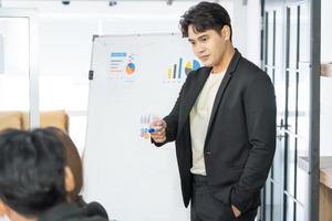 Selective Focus. Business presentation. project manager pointing at desktop presenting statistical data, briefing diverse group of employees. demonstrates statistics. photo