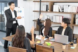 Business presentation. project manager pointing at desktop presenting statistical data, briefing diverse group of employees. demonstrates statistics. photo